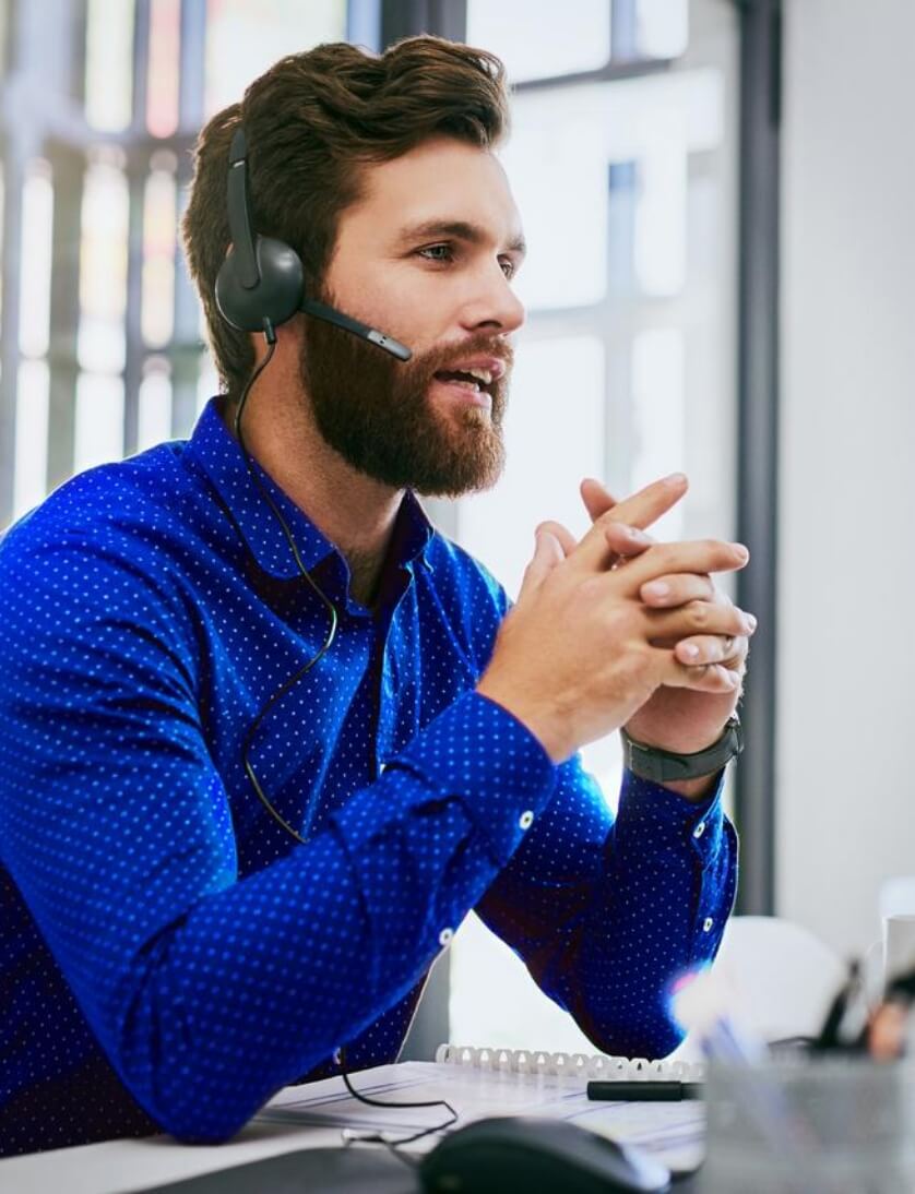 Young business man sitting at a desk in an office using a computer