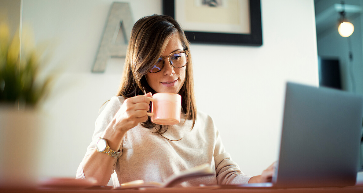 Woman with coffee researching on computer